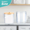 Clear acrylic detergent pod storage container with a wooden spoon on a white shelf.