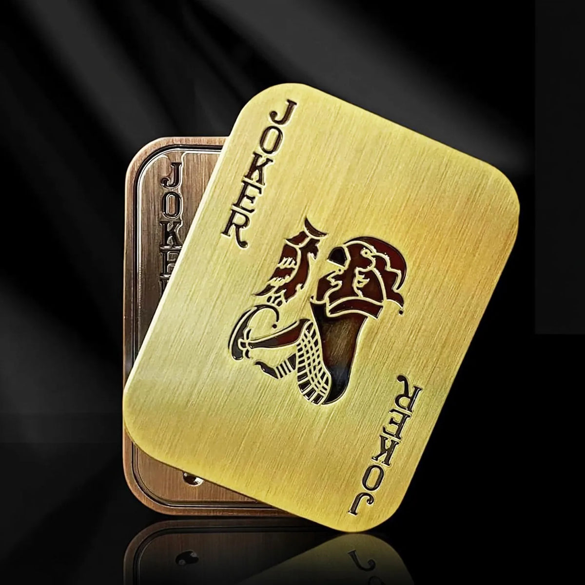 A gold-colored metal poker card featuring a joker design and the word Joker stamped on it.