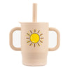A light beige silicone training cup with a straw and handles featuring a yellow sun design.