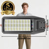 A man holds a solar-powered outdoor security light with a motion sensor and remote control, featuring five years warranty.
