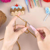 A hand is using a pink crochet hook to thread yarn, next to a set of colorful aluminum alloy crochet hooks and a crocheted ca
