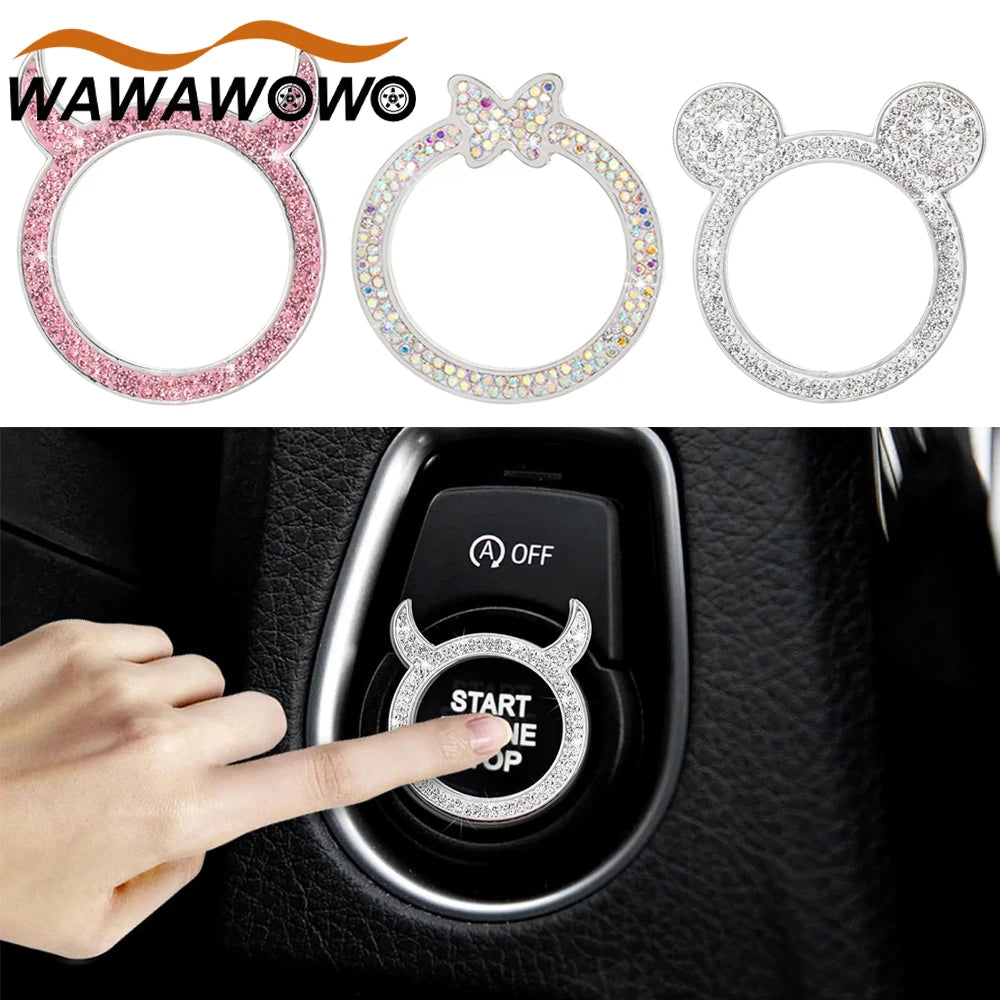 A hand presses the start button on a car ignition, next to various rhinestone-encrusted rings.