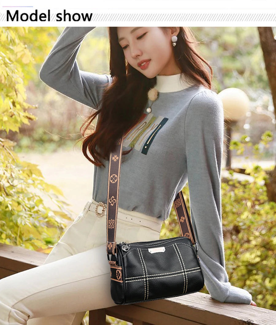 A woman models a black vintage genuine leather shoulder bag with gold accents and white pants in an outdoor setting.