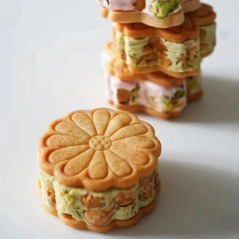 A stack of cookies decorated with floral designs, including cherry blossom, peach blossom, and sunflower patterns.