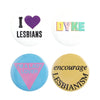 A set of four tinplate pins featuring designs for lesbians, including 'I love lesbians,' 'Dyke,' and 'I'm a lady lover.'