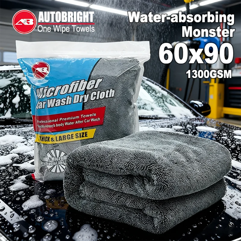 Eine Tasche mit Mikrofasertrocken für das Waschen eines Autos und ein Stapel dunkelgrauer Mikrofasertücher auf einer nassen s