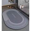 A gray bath mat with the word HOME embossed on it, placed on a bathroom floor.