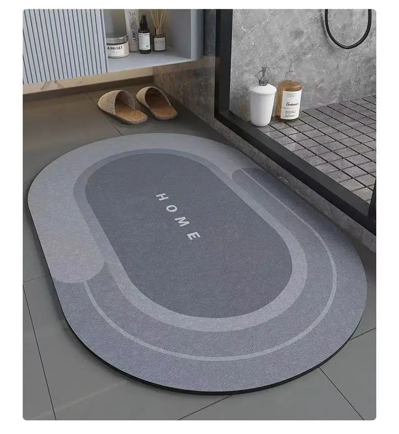A gray bath mat with the word HOME embossed on it, placed on a bathroom floor.