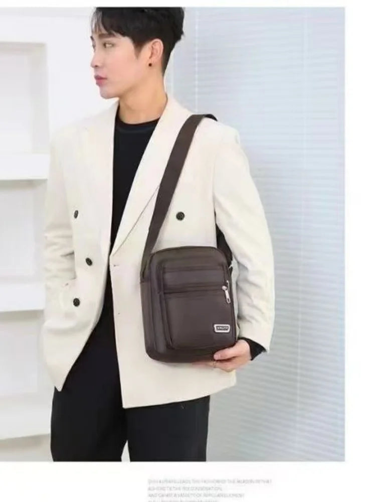 A model wearing a cream blazer and black shirt holds a brown multi-pocket crossbody chest bag.