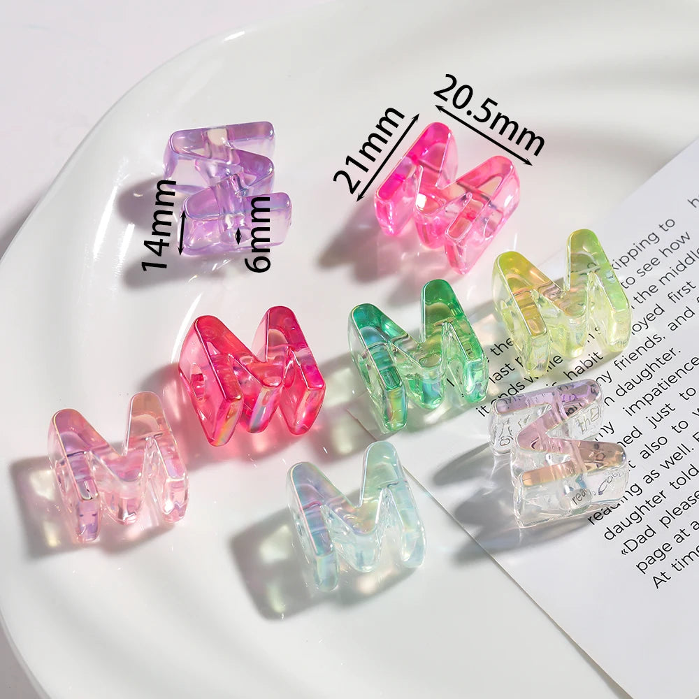A collection of colorful acrylic alphabet beads in various shades and sizes displayed on a white plate.