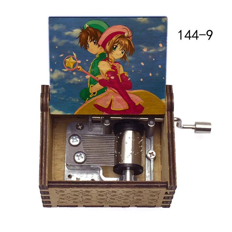 A music box featuring Cardcaptor Sakura characters, including Sakura, with a hand crank mechanism.