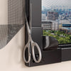 A pair of silver scissors is displayed next to a black magnetic window mosquito net frame.