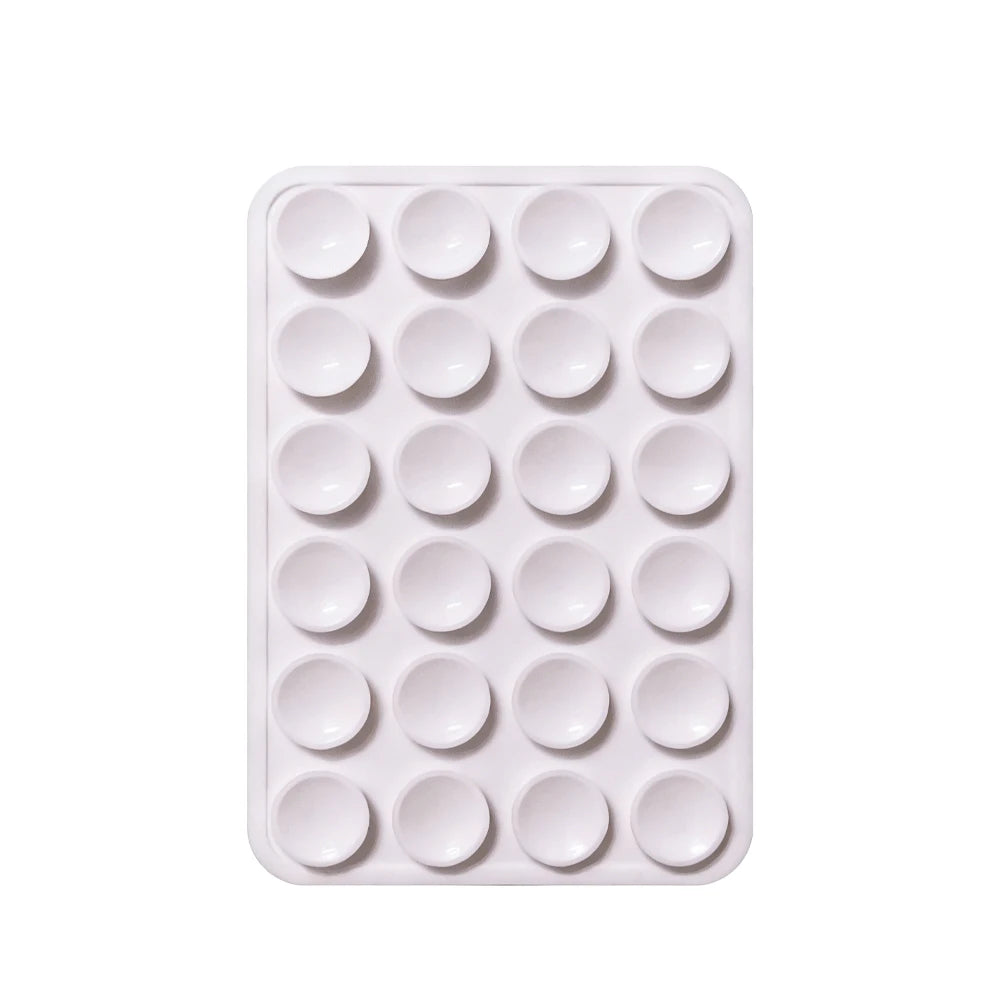 A white silicone suction pad with multiple circular indentations for phone mounts.