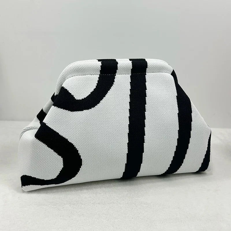 Bolso de crochet trenzado a rayas blancas y negras, visto de lado.