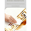 A hand wipes a gold-edged white PVC trim with a white cloth on a marble surface.