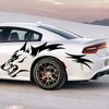 A white sports car features black wolf decals on the side, parked outdoors.