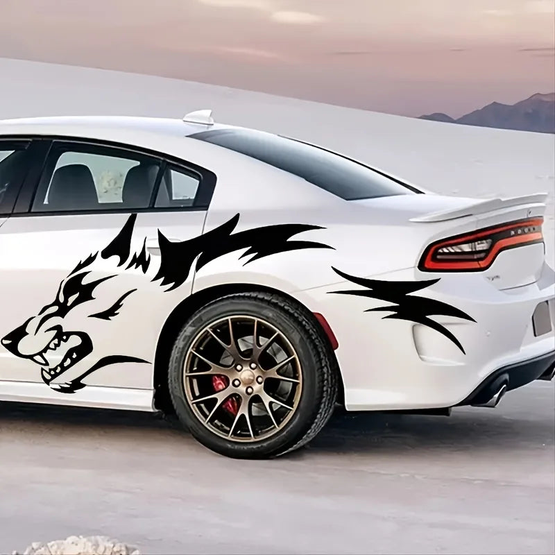 A white sports car features black wolf decals on the side, parked outdoors.