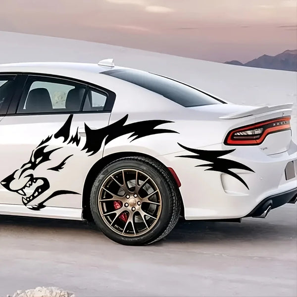 A white sports car features black wolf decals on the side, parked outdoors.