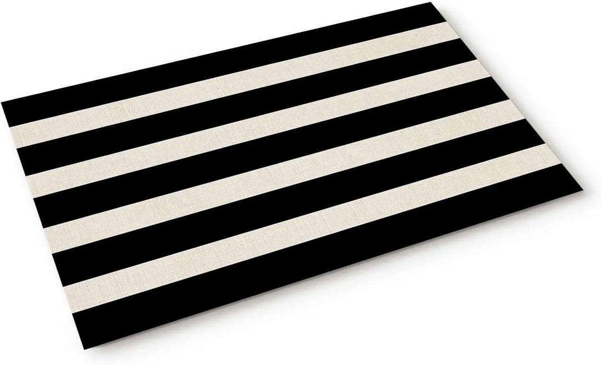 A rectangular black and white striped non-slip door mat viewed from above.