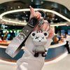 A hand holds a white bear-shaped keychain attached to a black leather key case.