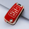 A red and gold protective TPU key fob cover for a vehicle, showing various key cutouts.
