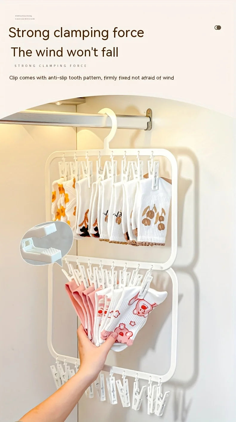 A hand is hanging white and pink t-shirts on a white clip laundry drying rack mounted on a wall.