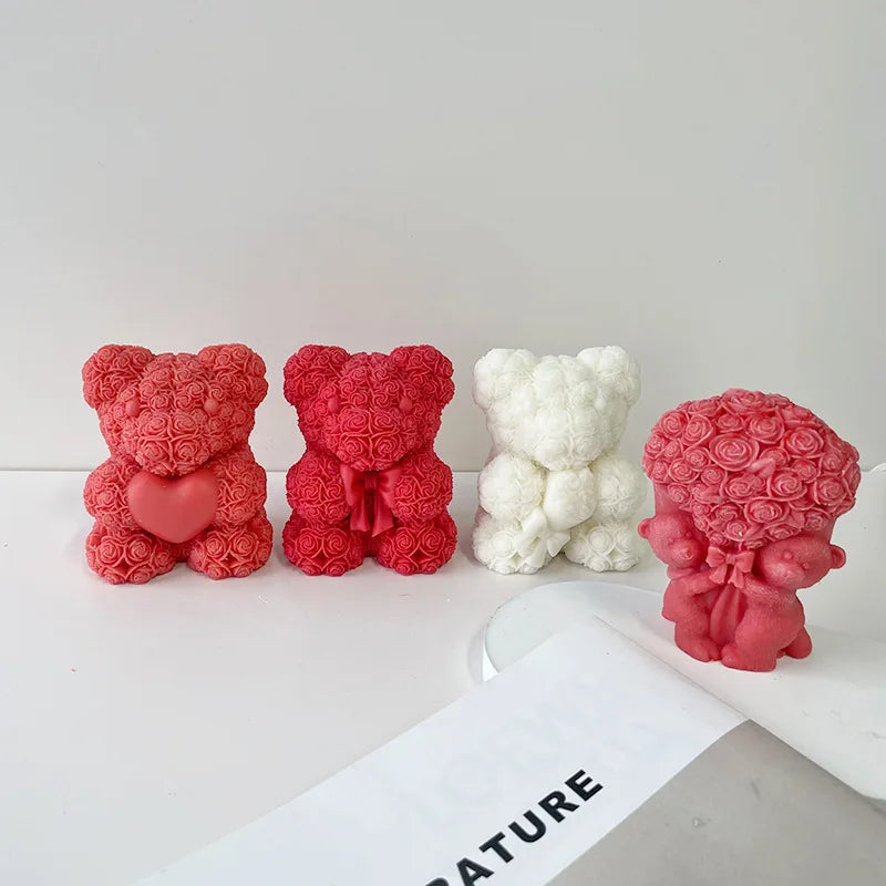 Three 3D rose bear silicone molds in pink and white colors displayed on a white surface.