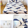 A fitted bed sheet featuring a geometric blue and white marbled print with an elastic band.