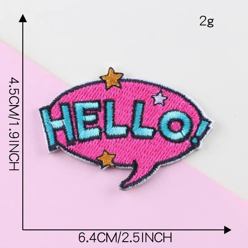 Pink embroidered lettering patch shaped like a speech bubble with the word HELLO in blue and gold stars
