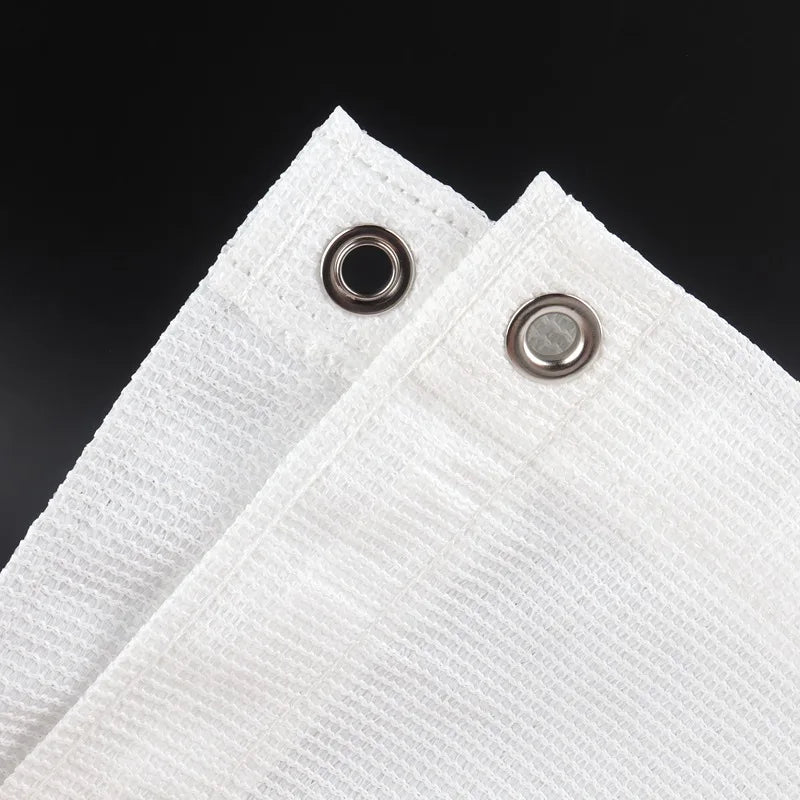 White HDPE privacy screen material with grommets, shown in a close-up view.