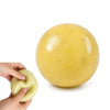 Una mano aprieta un juguete antiestrés grande, liso, amarillo y esférico.