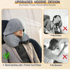 A gray hooded travel pillow with a hoodie design shown in use on an airplane seat.