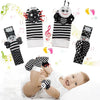A set of black and white baby rattle socks with sensory toys and a soft teether bootie being worn by a baby.