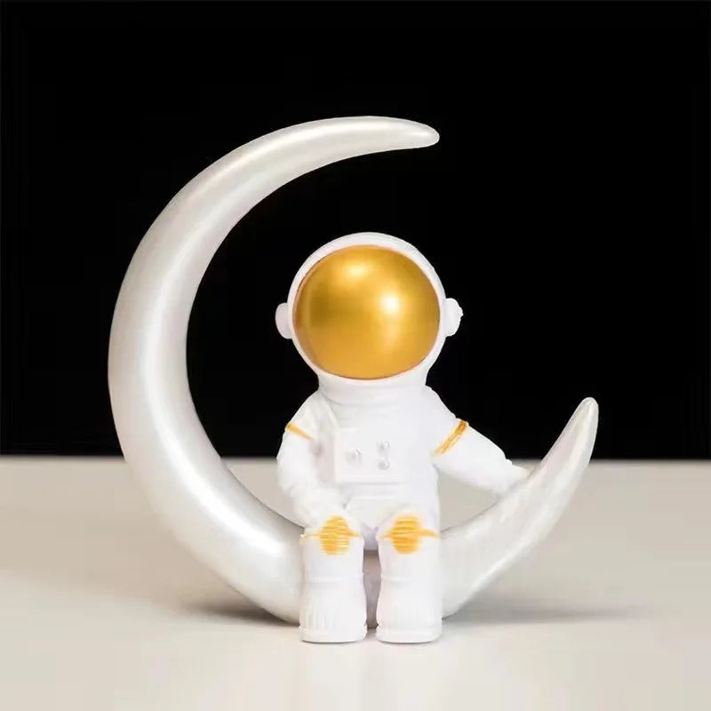 A white astronaut figurine with a gold helmet is displayed on a crescent moon shape.