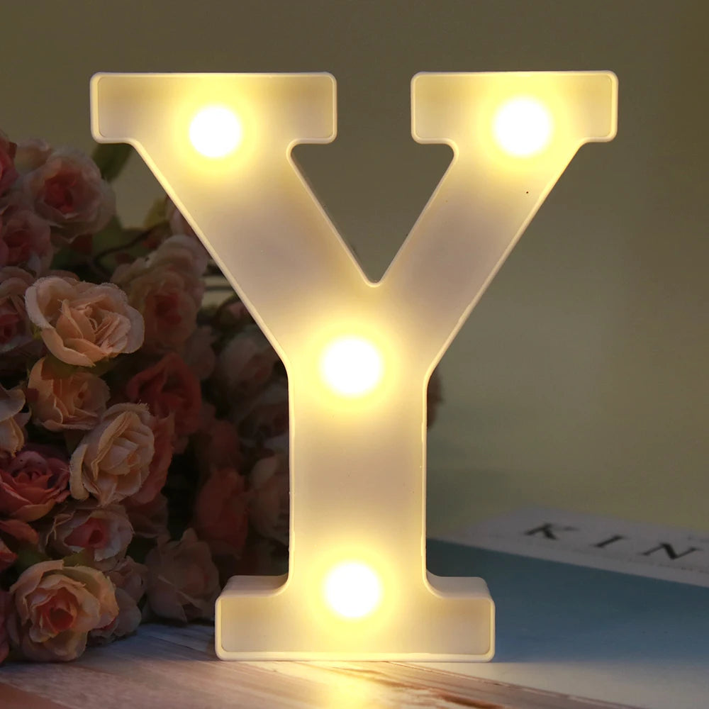 Lumière d'alphabet LED brillante en forme de lettre Y, veilleuse posée sur une surface en bois.