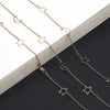 Gold-toned star and crescent moon necklace chain with hollow pendants displayed on a dark background.