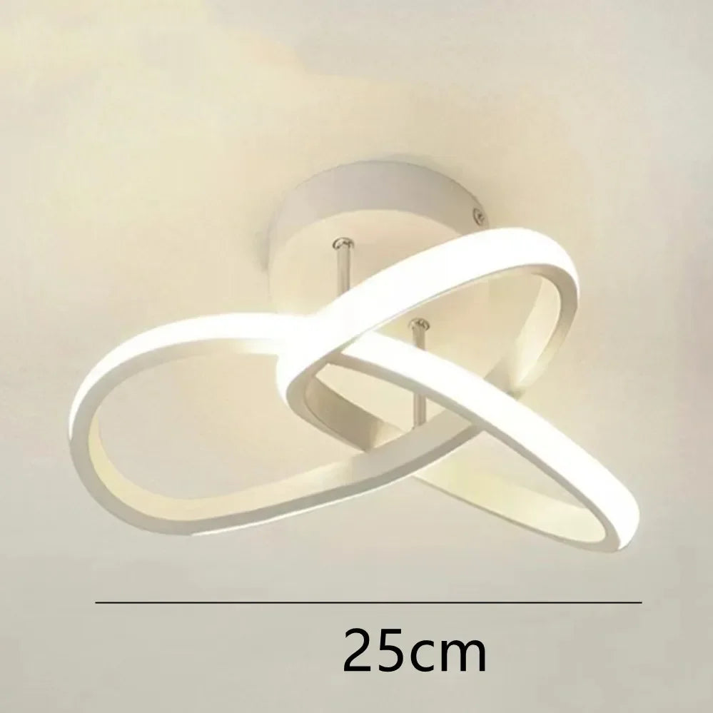 Modern white LED ceiling light shaped like a clover or infinity symbol mounted on a ceiling.