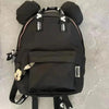 A black Mickey Mouse-themed backpack with a cow print design and a front pocket.