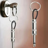 A vintage guitar amplifier wall key holder with a silver and black keyring hanging on a wall.