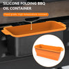 An orange silicone folding BBQ oil container sitting in a black cooking pan.