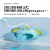A light blue shower head is spraying water into a bathtub, demonstrating the function of the Pupu elephant bath toy.