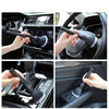 Hands cleaning the interior of a car using a soft bristle detailing brush.