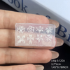 A hand holds a clear silicone mold with floral nail art designs on it.