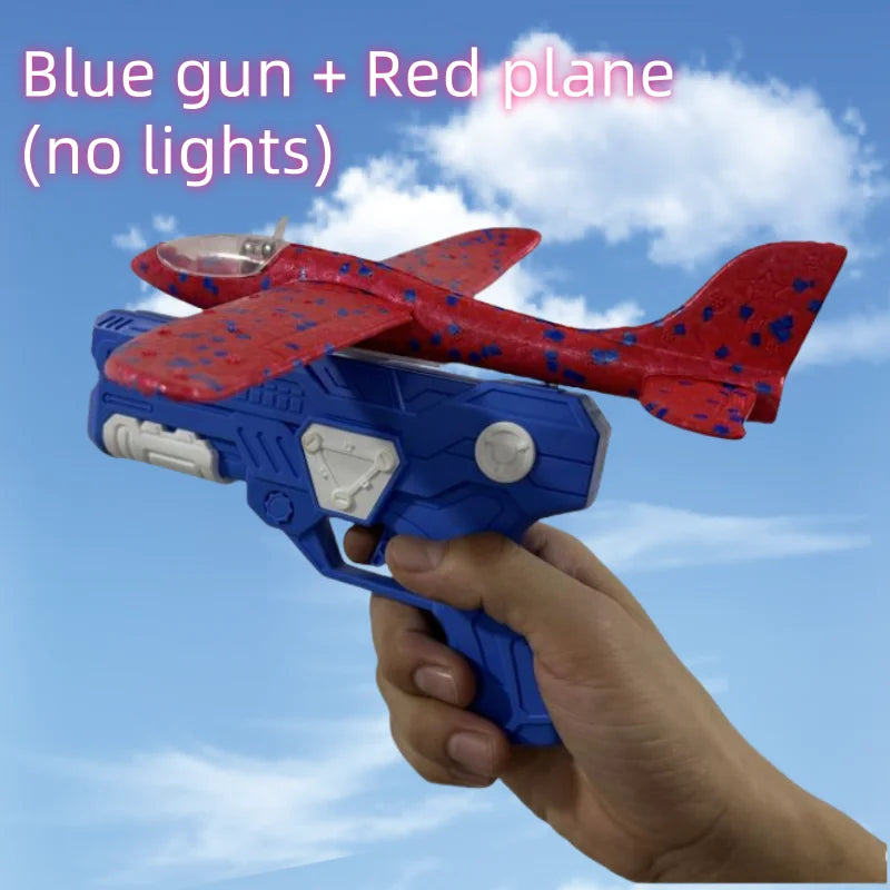A hand holds a blue and red foam plane catapult launcher against a cloudy sky.
