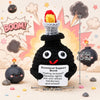 A black crochet bomb shaped like a face with red eyes and a yellow top, displayed on a light surface.