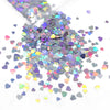 A close-up view of iridescent holographic star sequins scattered on a white surface.