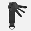 A black minimalist aluminum key organizer with a handle and multiple slots for holding keys.