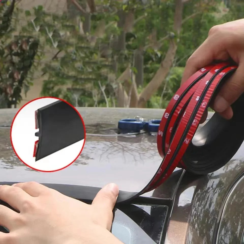 A hand is applying red weather seal strips to the door or window of a car.