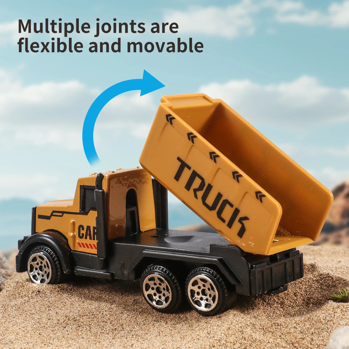 A yellow toy truck with an open bed is shown on sand, demonstrating flexible joints.