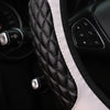 Close-up of a black quilted steering wheel cover with white piping and controls.